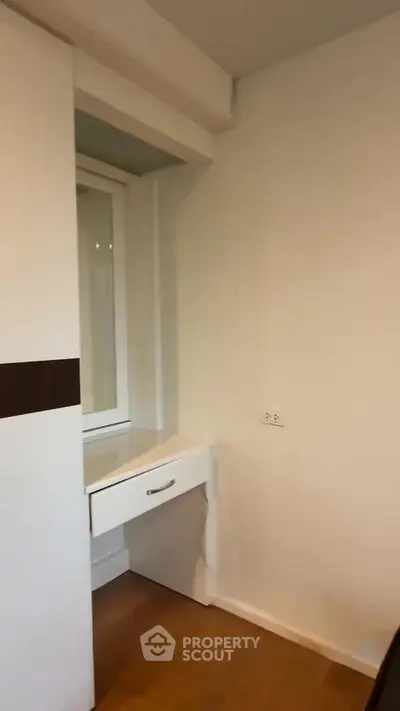 Compact study nook with built-in desk and window in modern apartment.
