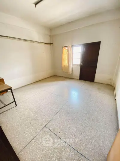Spacious unfurnished room with natural light and simple decor, ideal for customization.
