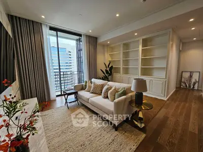 Elegant living room with hardwood floors, modern furniture, and access to a sunlit balcony, showcasing a perfect blend of comfort and style.