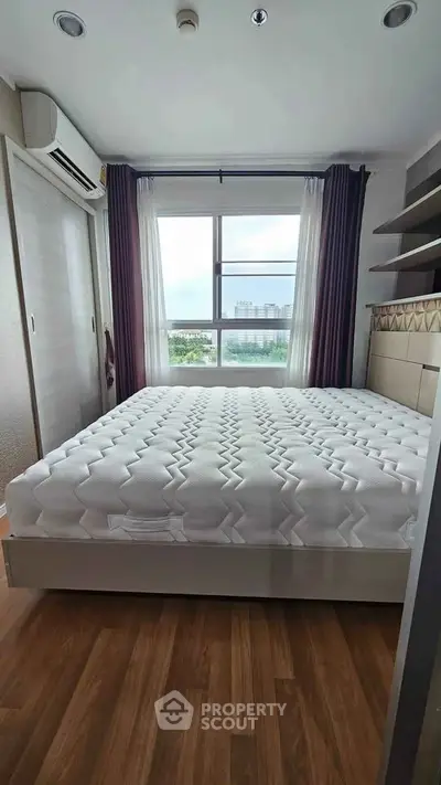 Modern bedroom with large window and stylish decor, featuring a comfortable bed and wooden flooring.
