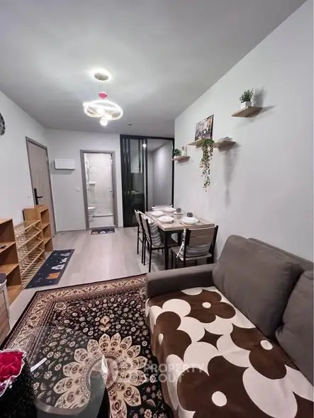 Modern living room with stylish decor and dining area, featuring contemporary lighting and cozy seating.