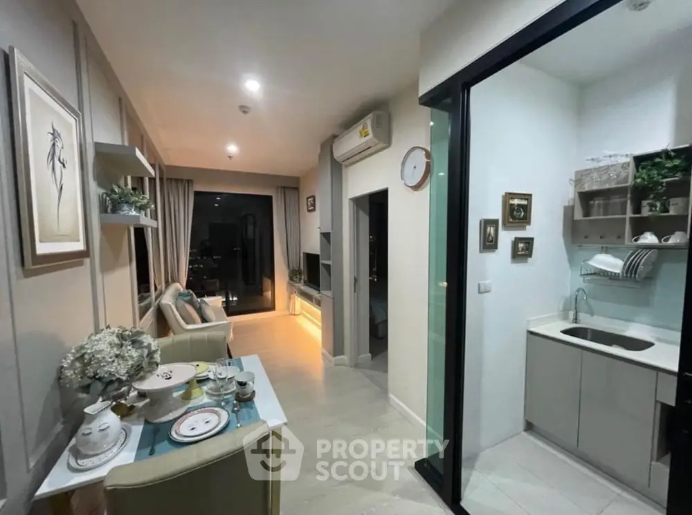 Modern open-layout living room with dining area and stylish kitchen, featuring elegant decor and city view.