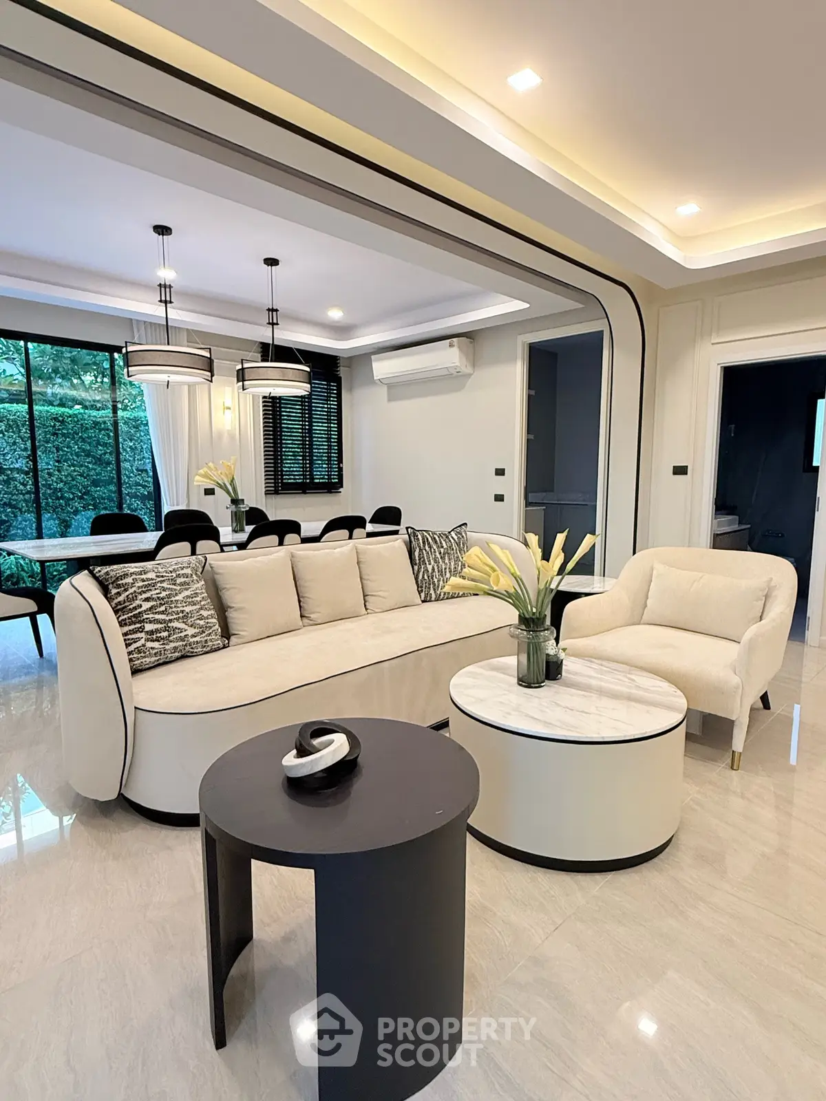 Luxurious modern living room with elegant furniture and open dining area, perfect for entertaining.