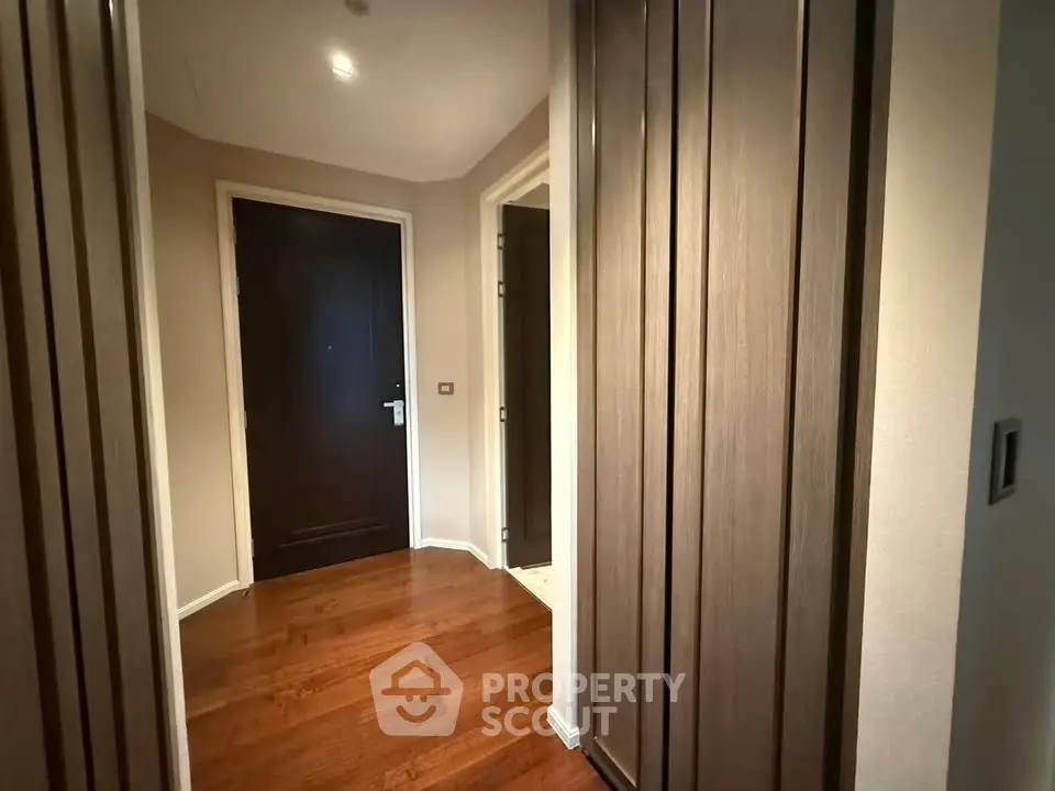 Elegant hallway with wooden flooring and modern doors in a stylish apartment.
