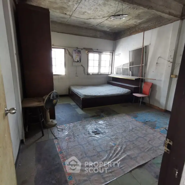 Spacious bedroom with natural light and potential for renovation