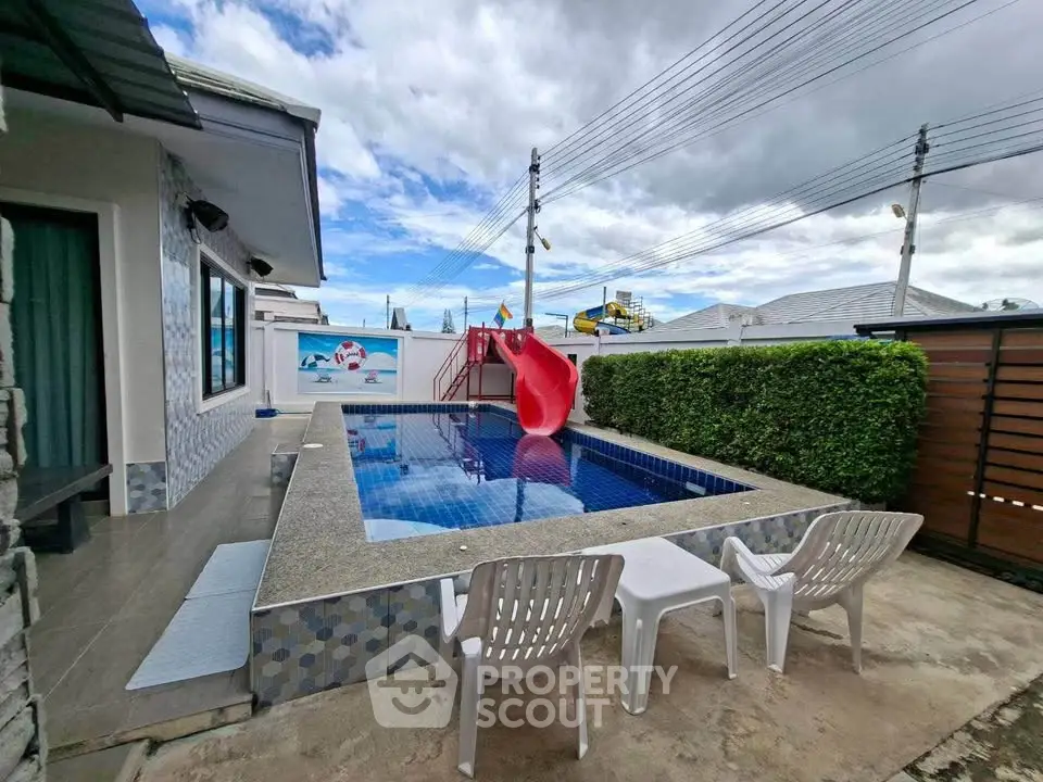 Charming backyard pool with slide, perfect for family fun and relaxation in a serene residential setting.