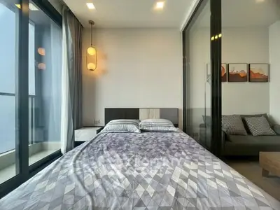 Modern bedroom with large windows and stylish decor in a high-rise apartment.