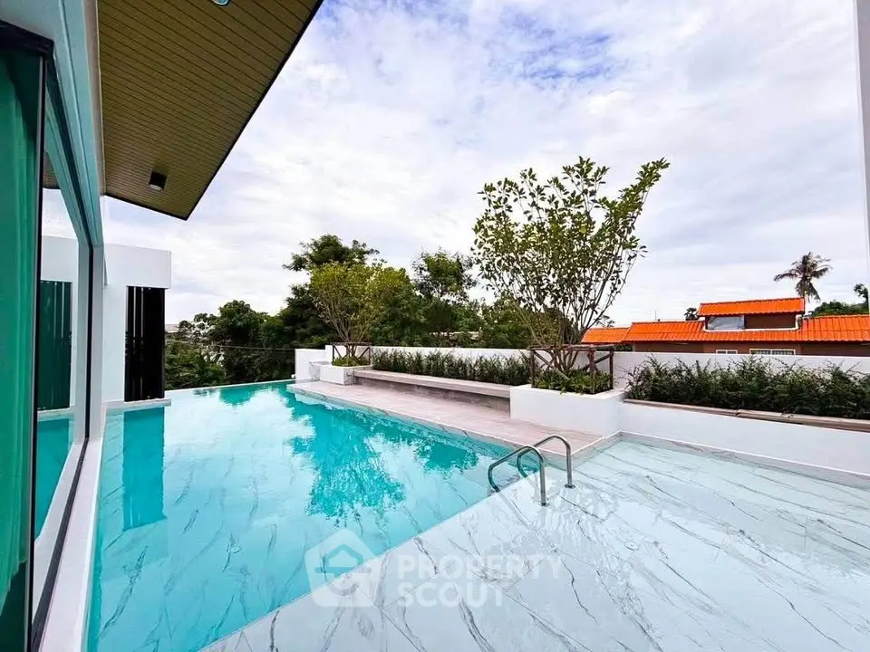Luxurious modern home with stunning outdoor pool and lush greenery, perfect for relaxation and entertainment.