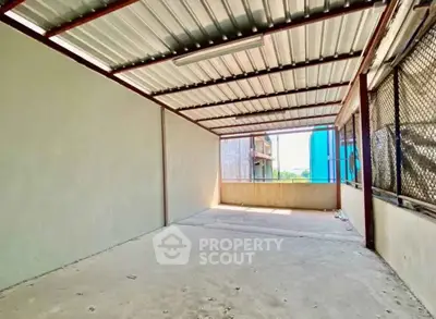 Spacious covered outdoor area with metal roofing and open sides, ideal for versatile use.
