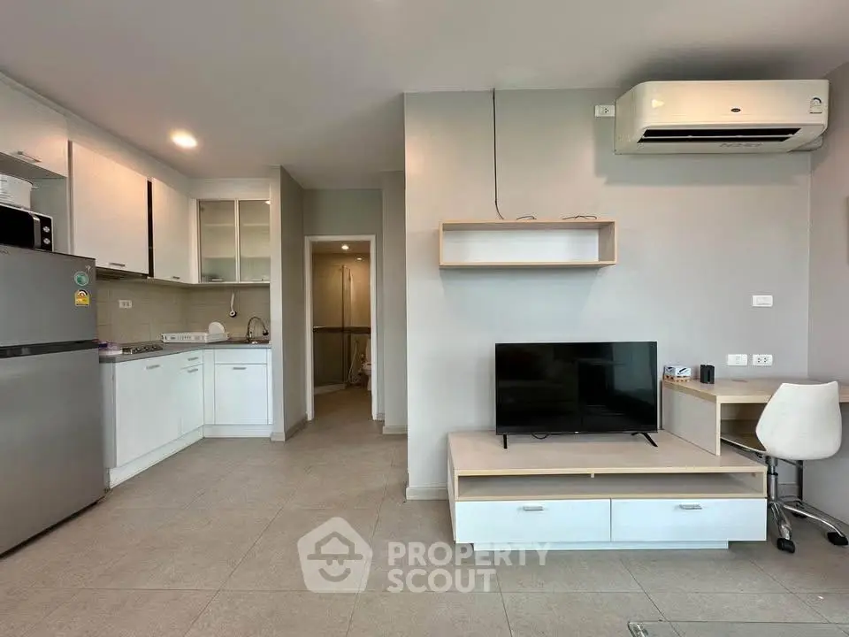 Modern open-plan living room with sleek kitchen and air conditioning in a stylish apartment.