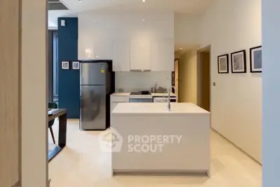Modern kitchen with sleek white cabinetry and central island in a stylish apartment.