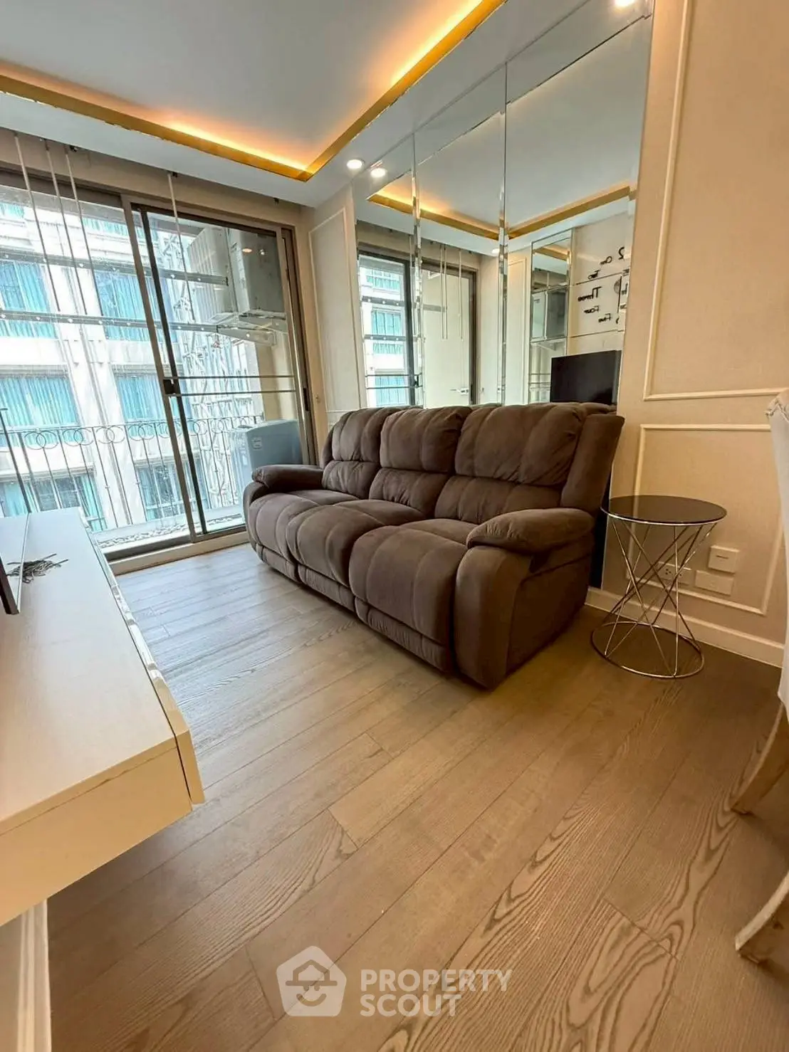 Modern living room with cozy sofa and mirrored wall in stylish apartment