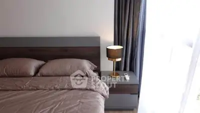 Modern bedroom with stylish bed and elegant lamp by the window.