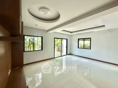 Spacious modern living room with large windows and elegant ceiling design