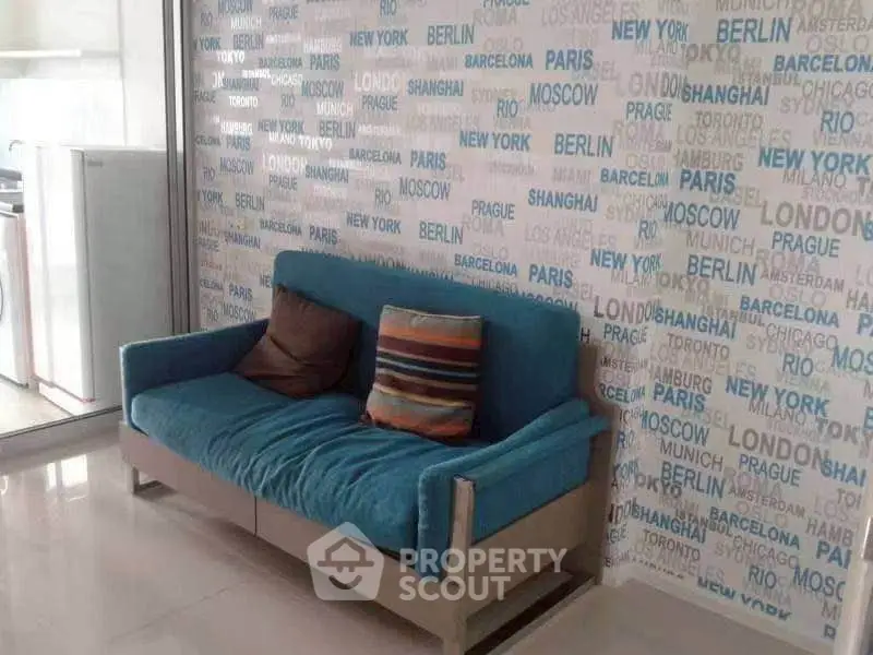 Stylish living room with vibrant blue sofa and city-themed wallpaper, perfect for urban living.