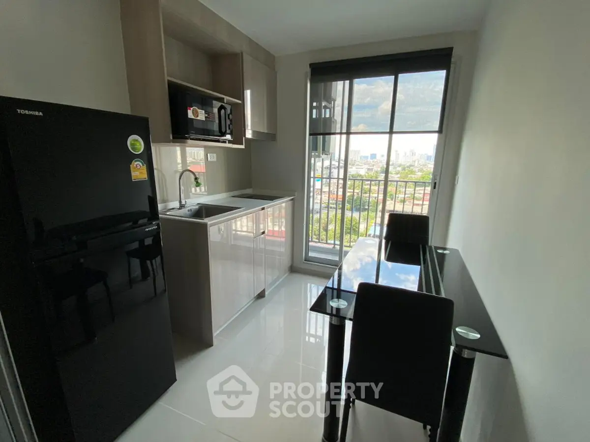 Modern kitchen with sleek appliances and dining area, featuring a large window with city view.
