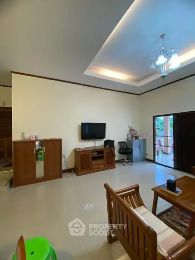 Spacious living room with modern furniture and natural light, perfect for relaxation and entertainment.