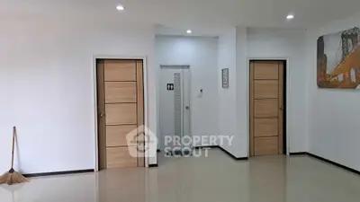 Spacious interior with modern wooden doors and minimalistic decor.