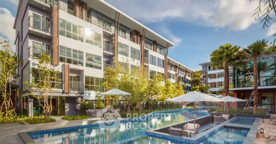 Luxurious modern apartment complex with stunning pool and lush greenery.