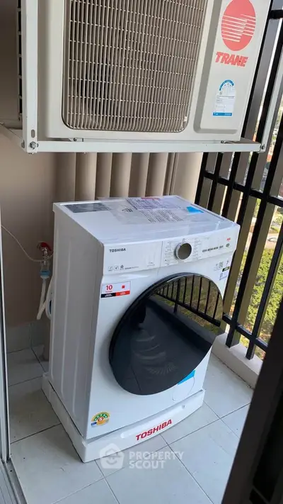 Modern balcony with washing machine and air conditioning unit, perfect for urban living convenience.