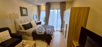 Modern bedroom with stylish decor, cozy bed, and natural light from large windows.