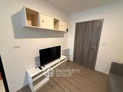 Modern living room with sleek TV stand and wall-mounted storage in cozy apartment.