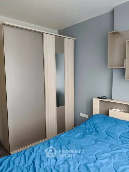Modern bedroom with sleek wardrobe and cozy blue bedding