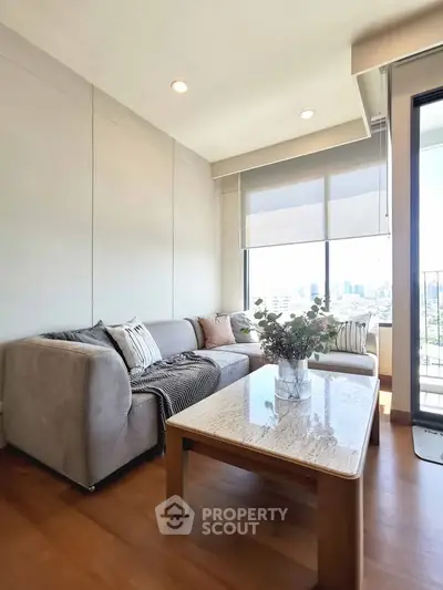 Modern living room with cozy sofa and city view from large windows