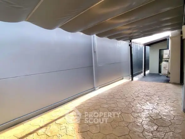 Spacious covered outdoor area with stamped concrete flooring and modern design.