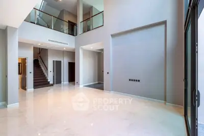 Spacious modern living room with high ceilings and elegant staircase