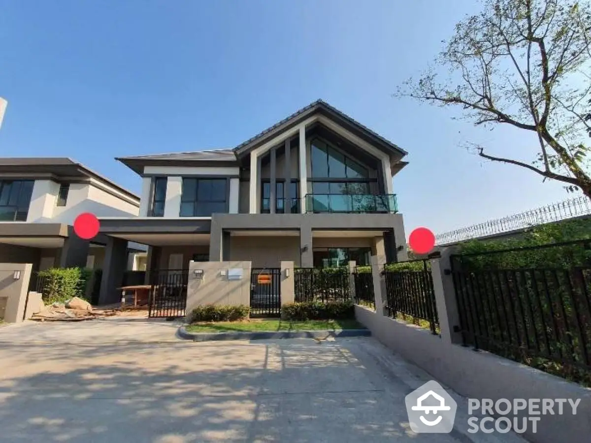 Modern two-story house with large windows and spacious driveway in a serene neighborhood.