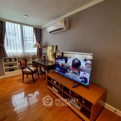 Charming living room with hardwood floors, elegant furniture, and a large window for natural light.