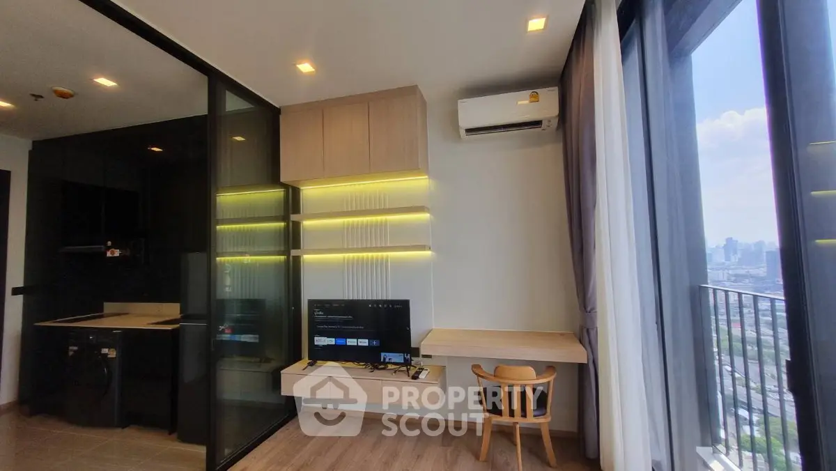 Modern apartment interior with balcony view, featuring sleek kitchen and cozy living area.
