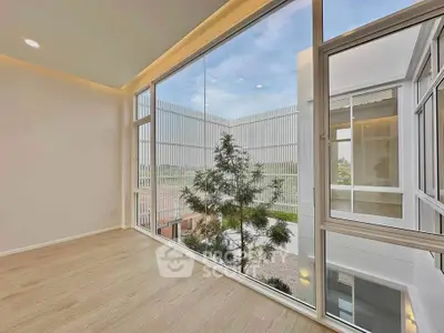 Modern interior with large windows offering a stunning view of contemporary architecture and greenery.