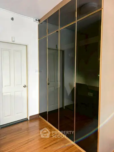 Sleek modern interior with mirrored wardrobe and wooden flooring