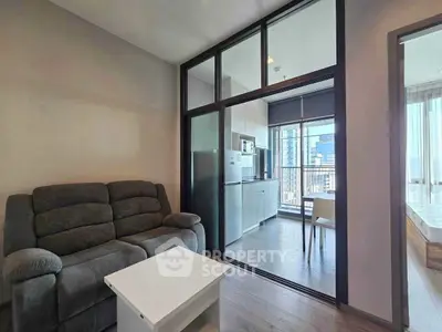 Modern apartment interior with cozy living room and open kitchen layout, featuring a balcony view.