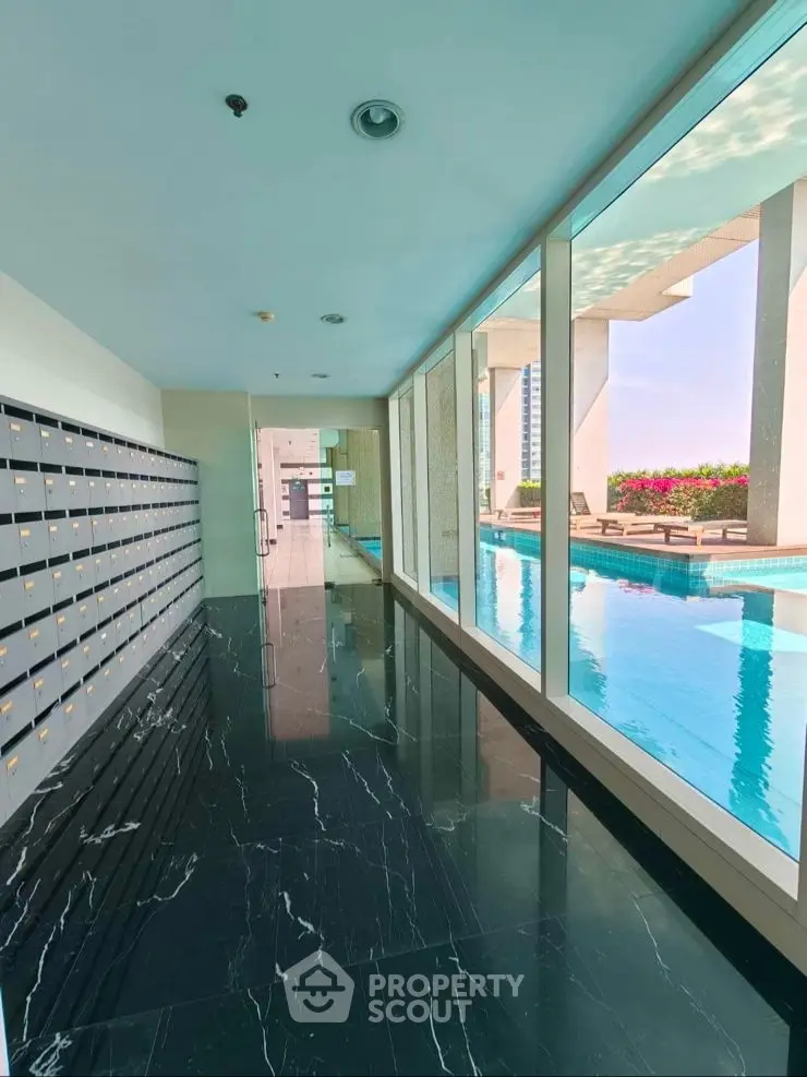 Luxurious high-rise poolside corridor with sleek black marble flooring and panoramic city views.