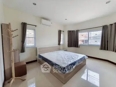 Spacious bedroom with large windows and modern furnishings