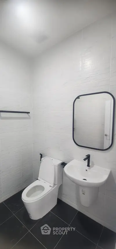 Modern bathroom with sleek fixtures and white tiled walls