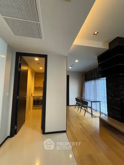 Modern apartment interior with open layout, featuring a stylish kitchen and spacious living area with natural light.