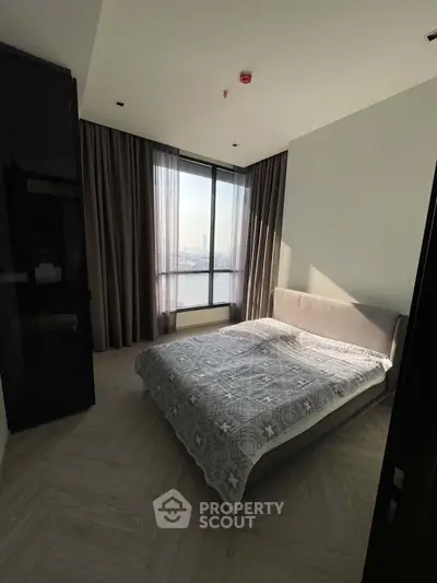 Modern bedroom with large window and stylish decor in high-rise apartment