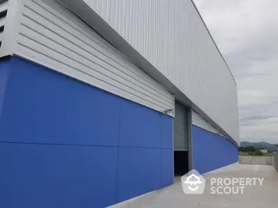 Modern industrial warehouse exterior with blue and white facade