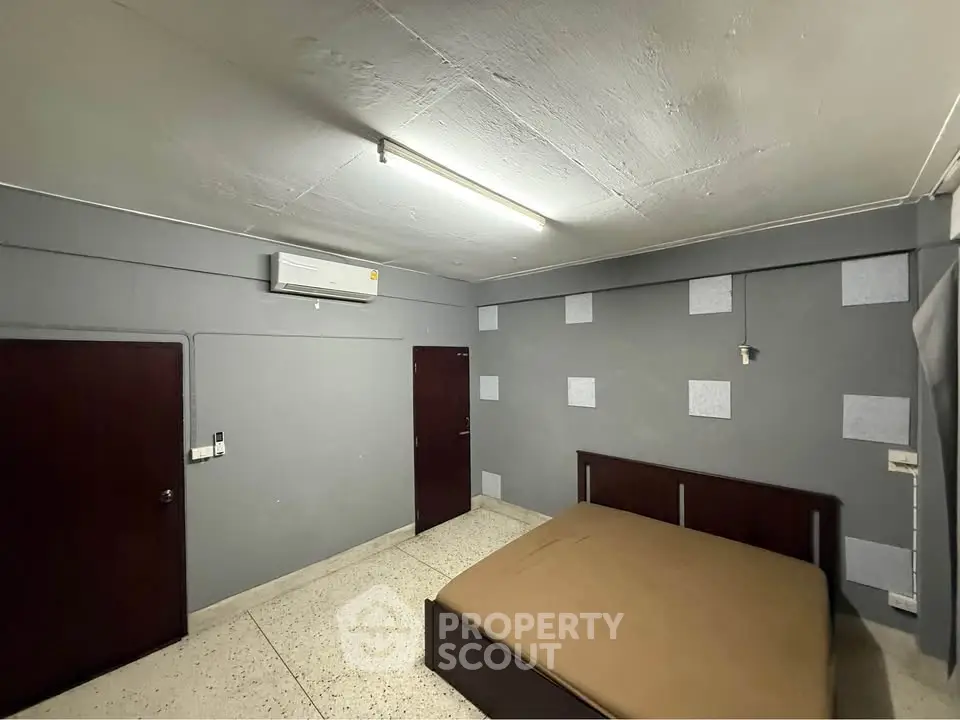 Spacious bedroom with modern decor and air conditioning in a stylish apartment.