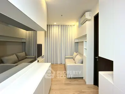 Modern living room with sleek design and neutral tones, featuring a cozy sofa and air conditioning.