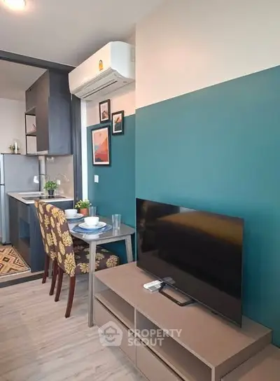 Modern living room with stylish decor and compact kitchen in open layout apartment.