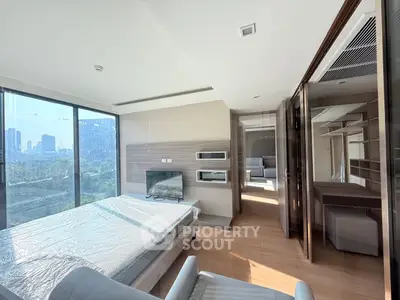 Modern bedroom with large windows and city view, featuring sleek design and ample natural light.