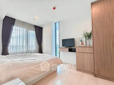 Modern bedroom with large window, stylish furniture, and natural light.