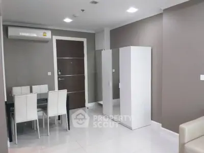 Modern apartment interior with dining area and wardrobe, featuring sleek design and neutral tones.
