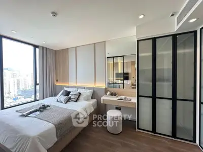 Modern bedroom with city view, featuring sleek design and ample natural light.