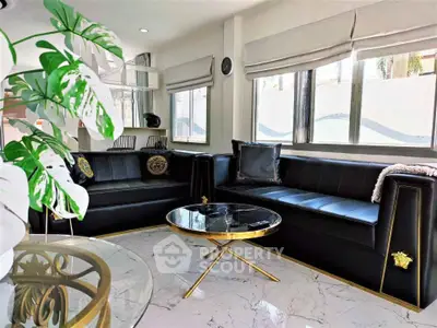 Luxurious living room with black leather sofas and elegant marble flooring